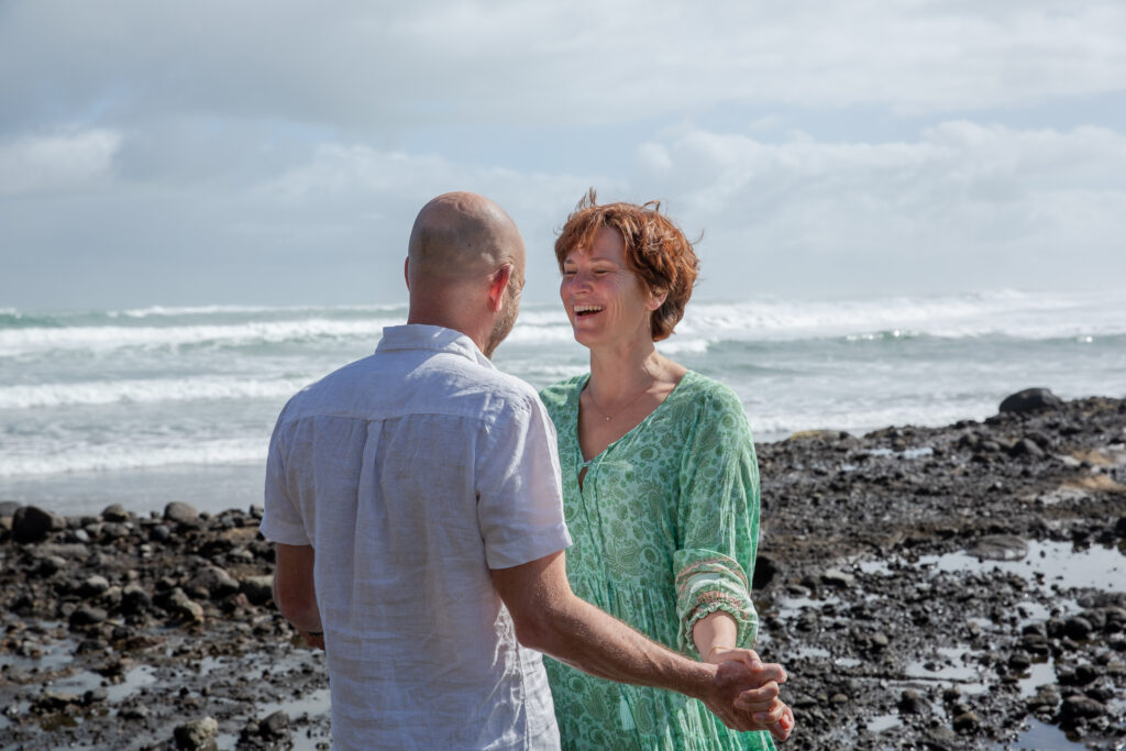 Mark and Tarisha holding hands by the sea