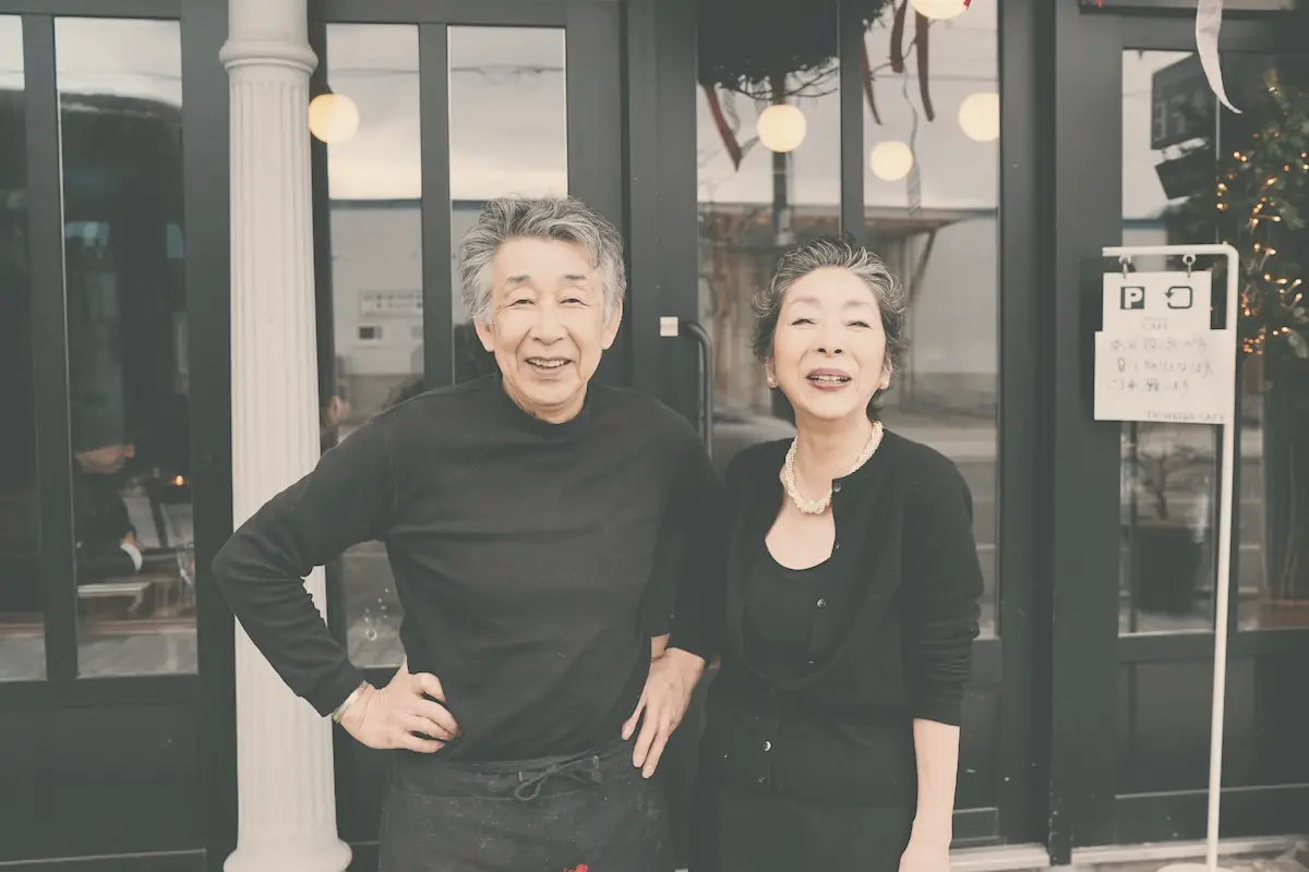 An older couple smiling together outside their home