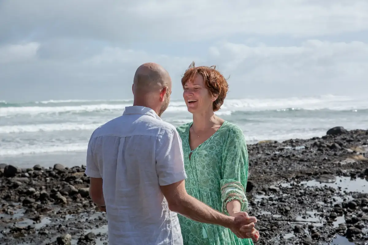 Mark listening and laughing with Tarisha by the sea at Piha
