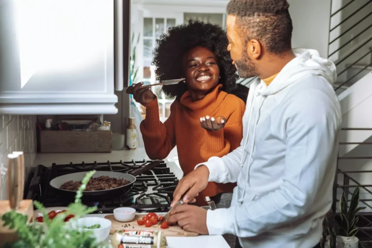 Couple laughing while cooking together