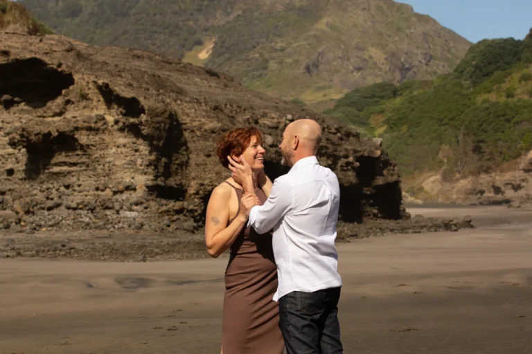 Mark about to kiss Tarisha on a black sand beach