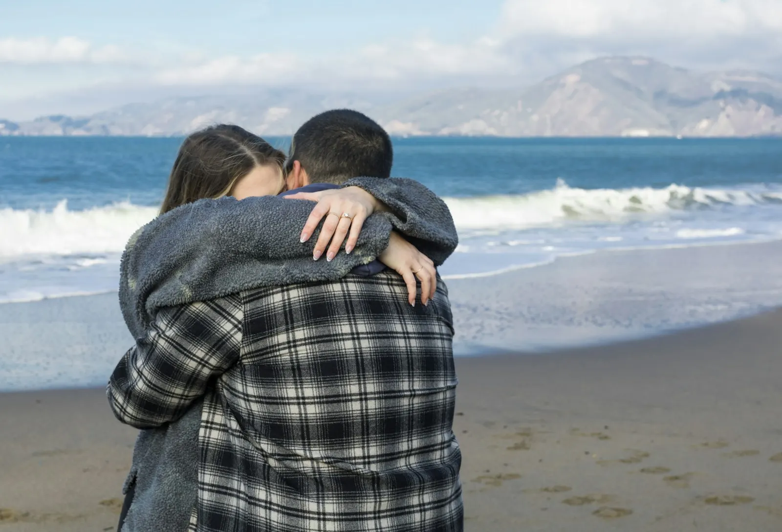 Couple holding each other close on the beach