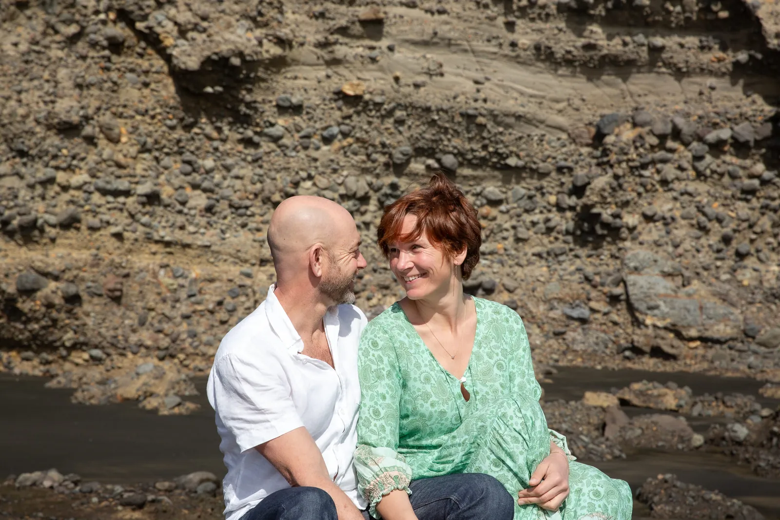 Tarisha and Mark sitting together on the rocks, talking