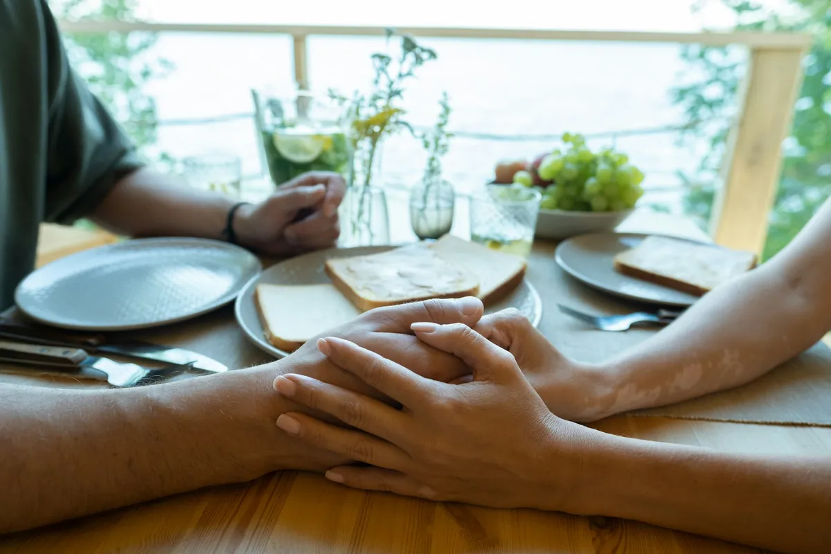 Couple holding hands across a table