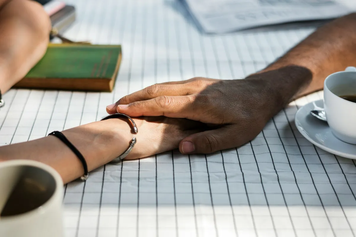 Couple holding hands across a table
