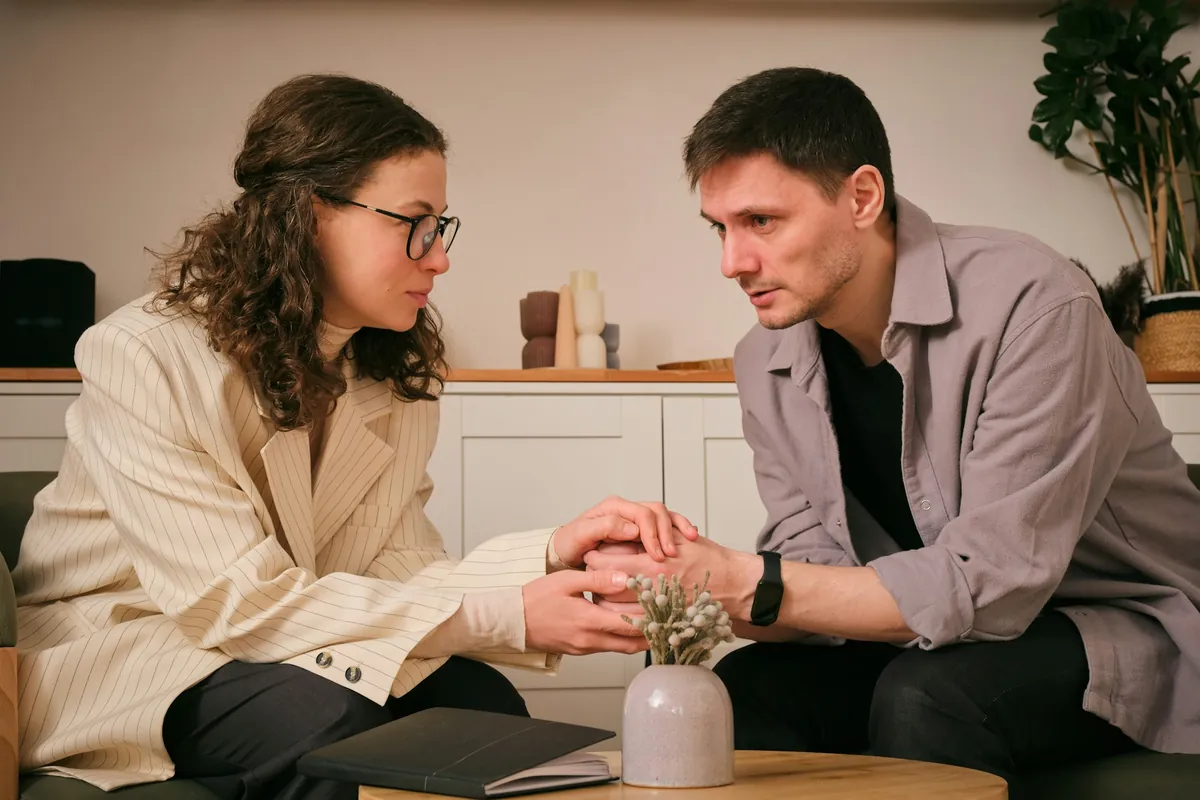 Couple holding hands in a serious conversation