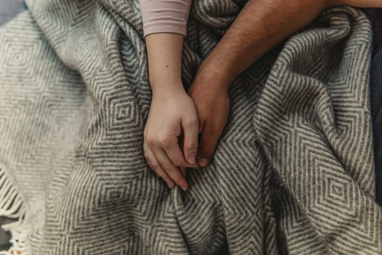 Couple holding hands on a blanket