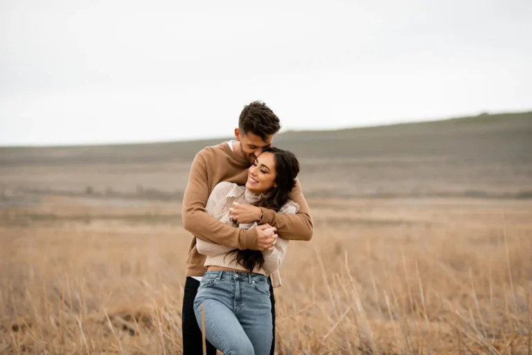 Couple hugging tightly in a field