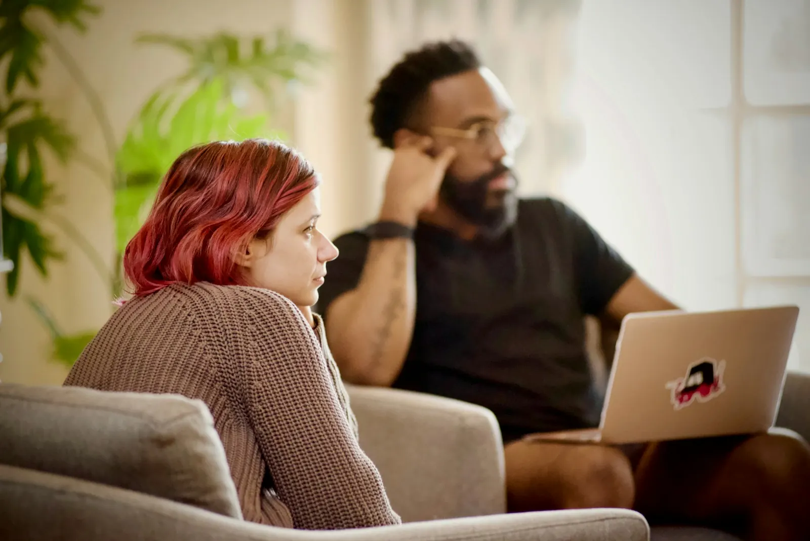 Couple on the sofa looking at a laptop together