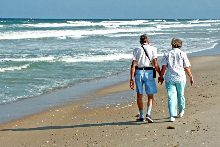 Long-term couple walking hand in hand on the beach