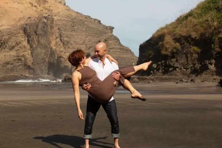 Mark carrying Tarisha on Piha beach