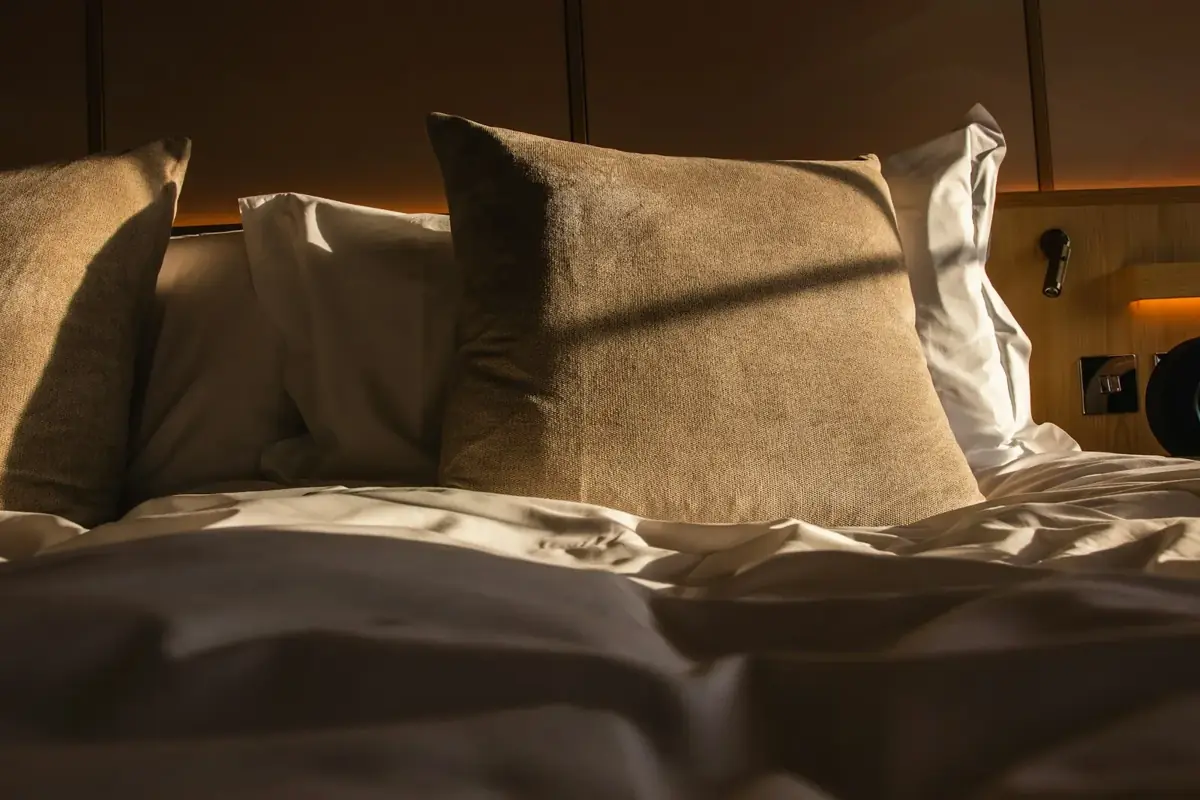 An unmade bed in soft morning light