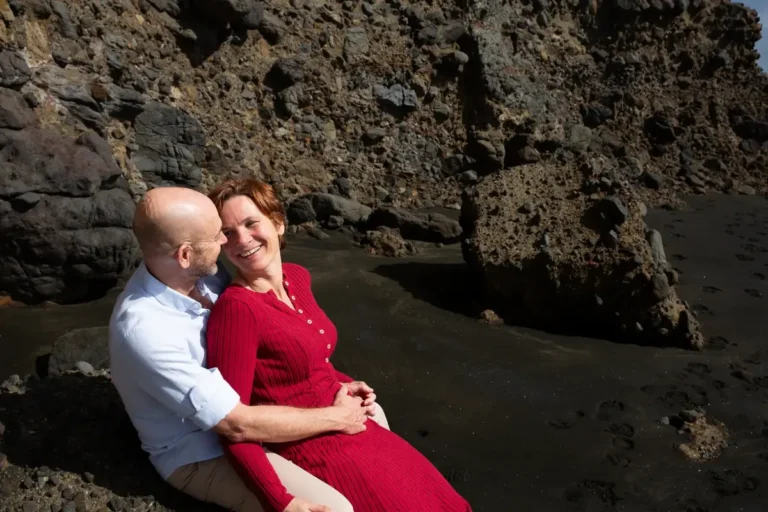 Mark and Tarisha looking at each other on the rocks at Piha