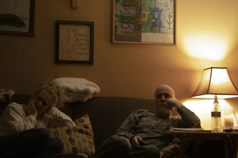 Couple sitting apart on the couch in the evening