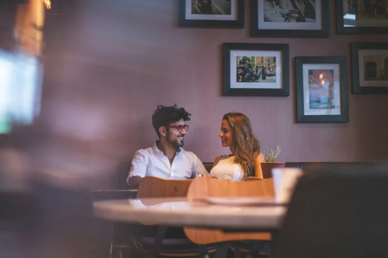 Couple sitting at a table, distant from each other