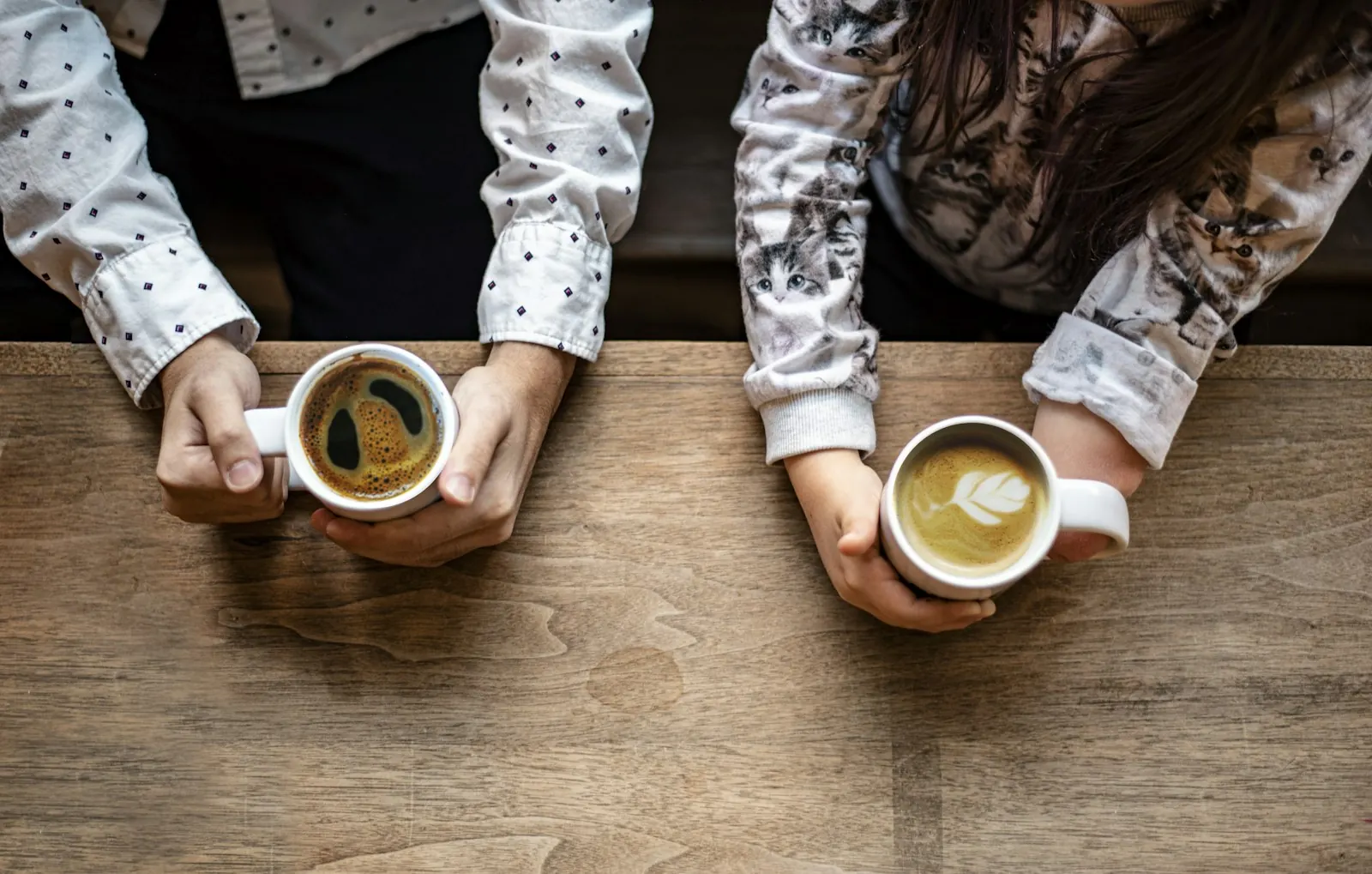 Couple sharing morning coffee at a wooden table