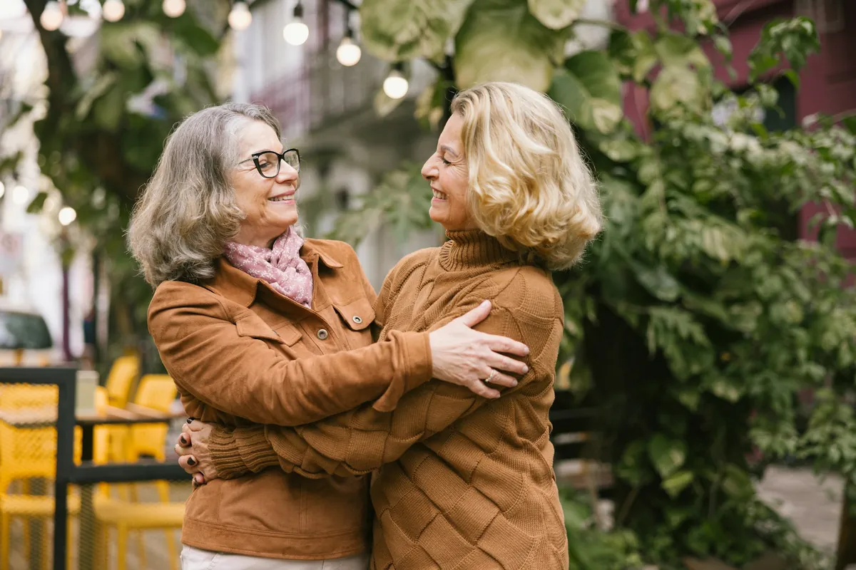 Two older women hugging outdoors
