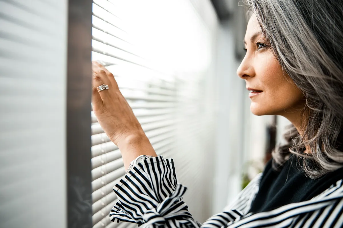 Woman looking out of a window, deep in thought