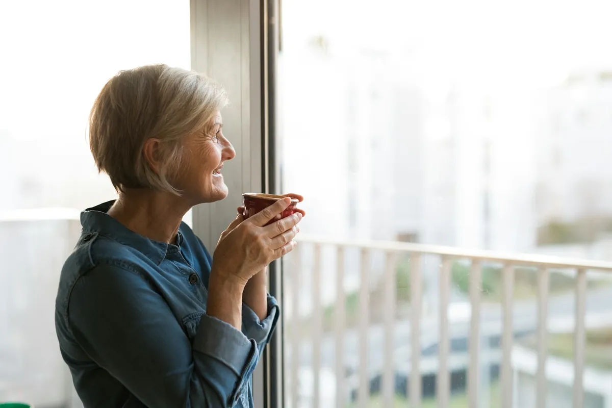 Woman looking out of a window, deep in thought